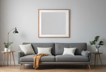 A modern living room with a gray sofa, white walls, and a large empty wooden frame on the wall.