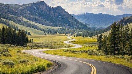 Fototapeta premium A scenic drive through Yellowstone, with the road winding through lush meadows and towering mountains.