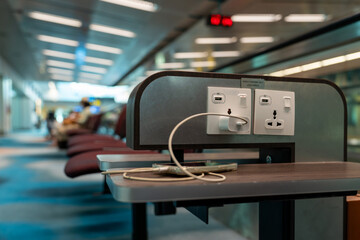 Plug socket or USB port for free charging mobile phone or laptip in the airport terminal service...