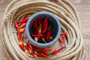 red chili pepper in a mortar, fresh vegetables on a selective background