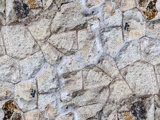 light stone wall uneven close-up, hard surface weathered