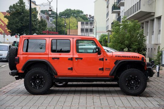 Mulhouse - France - 4 september 2024 - profile view of orange Jeep rubicon parked in the street