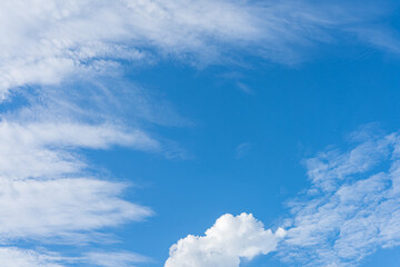 Fluffy white clouds drift across a vibrant blue sky, creating a breathtaking natural canvas