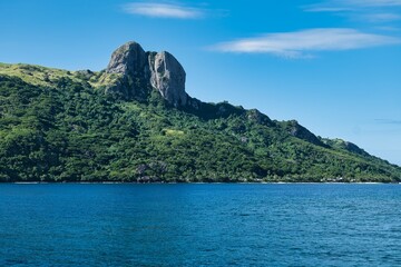 Blue sea and lush green hills, volcanic rocks, and cliffs of the islands of the Yasawa archipelago, Fiji. Tropic vacation. Small and beautiful, paradise-like isles close to the main islands of Fiji. 