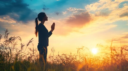 Profile of a woman praying at sunset