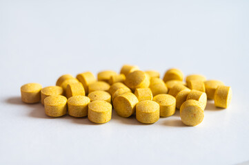 Medical tablets, placed next to each other on a white surface. Therapies, medicines and supplements.