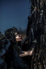 Goddess of death with black wings on a dried field