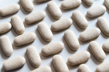 Medical tablets, placed next to each other on a white surface. Therapies, medicines and supplements.