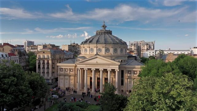 Romanian Atheneum in Bucharest during a summer sunset. Aerial 4k video of this amazing landmark historical building from Bucharest, Romania, on Victoriei Avenue (Calea Victoriei). Travel to Romania.