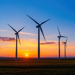 Fototapeta premium Breathtaking sunset over wind turbines, showcasing renewable energy and nature's beauty in a tranquil landscape.