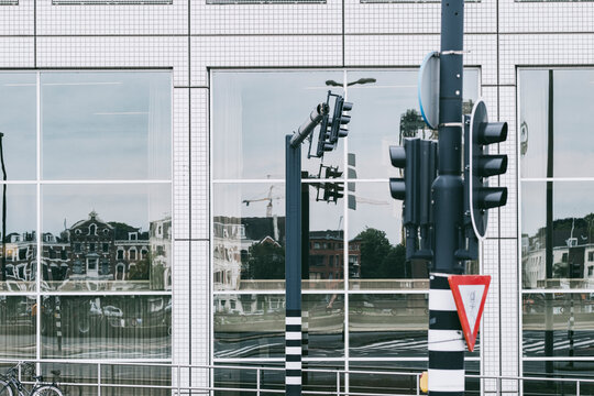 Modern glass building reflecting the surrounding urban landscape, including historic architectural elements, symbolizing the fusion of the past and present in urban growth.