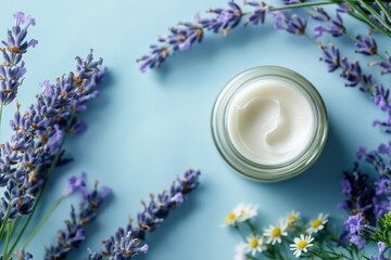 Jar of cream with lavender and chamomile flowers on a blue background