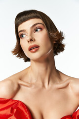 Obraz premium A stylish young woman showcases elegance in a vibrant red dress.
