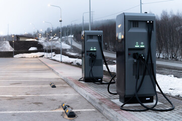 new electric charging station against the backdrop of misty mountains and the road leading to a holiday resort