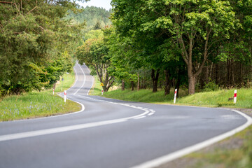 An asphalt road going through a forest in Masuria