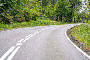 An asphalt road going through a forest in Masuria