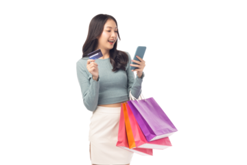 Young asian lady using mobile phone holding credit card carry shopping bags isolated over pastel green background and copy space Smiling young girl purchasing online through phone using credit card