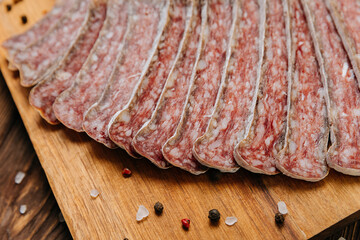 Close-up of sliced dry-cured salami on board, ideal for gourmet food and charcuterie presentations