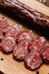 Close-up of thinly sliced salami on a wooden board, showcasing rich marbling and gourmet quality