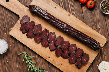 Sliced dark cured sausage on board, highlighting deep color and rich texture for gourmet appeal