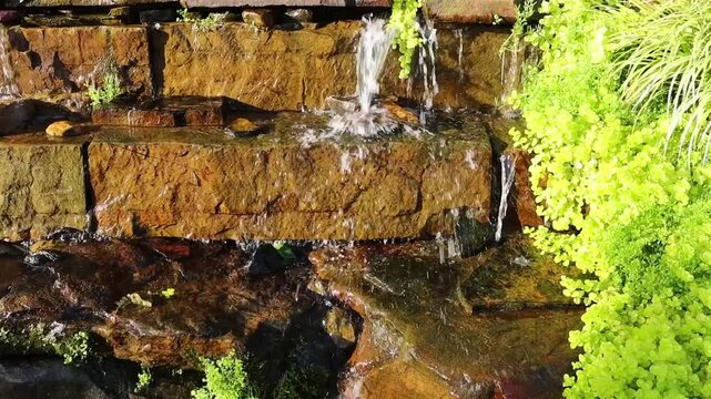 Minature water fall with rocks and plants.