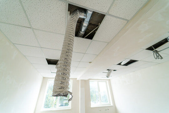 Ceiling repair in a room showing exposed ductwork and light fixtures. A room undergoing maintenance with exposed ductwork and lights revealing the ceiling&rsquo;s interior