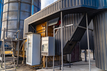 Grain storage facility with machinery for grain handling operations. A grain storage facility equipped with handling machinery operates under clear skies