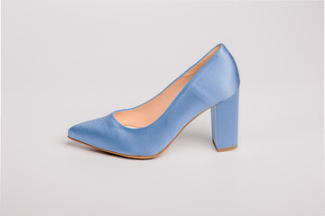 Elegant light blue satin shoe with high heels standing on white background