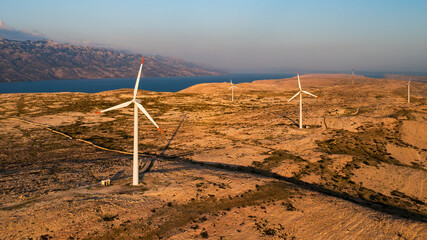 PAG ISLAND, CROATIA - JULY 14 2024: Wind turbines mounted near sea water on Pag Island. Coastline...