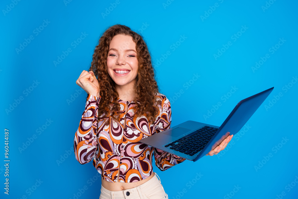 Canvas Prints Photo portrait of attractive young woman hold netbook winning excited dressed stylish colorful clothes isolated on blue color background