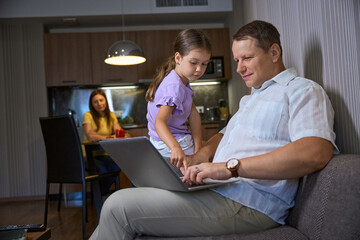 Naklejka premium Man works on a laptop on the sofa