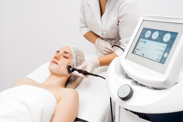 A cosmetologist performs RF lifting for facial rejuvenation and tightening. This non-invasive...