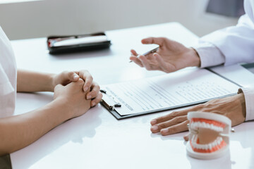 Fototapeta premium In a dental clinic, orthodontists and nurses work together to examine and treat patients' oral health. They discuss dental hygiene, repairs, and care while ensuring that the visit is comfortable.