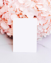 Obraz premium Mockup invitation or blank greeting card on a pink flower background