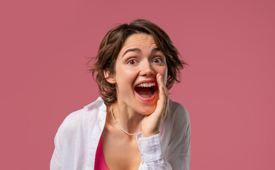 Attention, portrait of young woman shouting, holding hand near open mouth