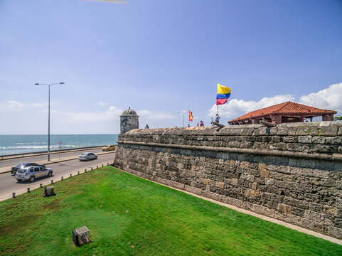 Cartagena de Indias historical walls and Colombian flag with the sea in the back - aerial shot in Colombia