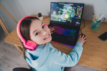 Top view photo of cheerful cute girl little gamer playing online video game indoors house