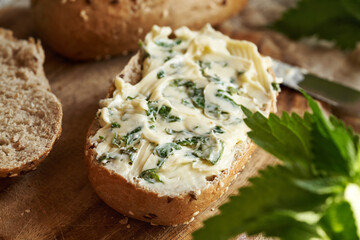Nettle butter - homemade bread spread made of wild edible plants, on a slice of sourdough bread, closeup