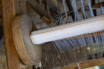 mechanism of a wooden loom with a bobbin of thread close-up, traditional carpet production