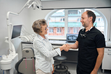 Specialist greets an elderly lady with a handshake