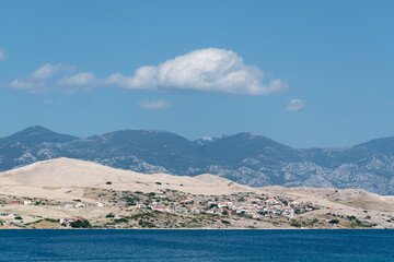 Pag island with coastal settlement and mountain Velebit in haze