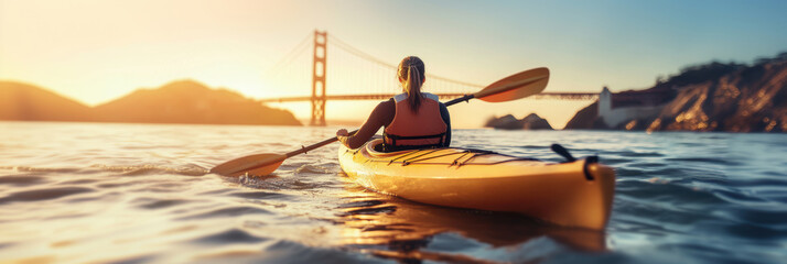 Obraz premium A woman kayaking in water with golden gate bridge