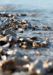 Small wave splashes over pebble on beach