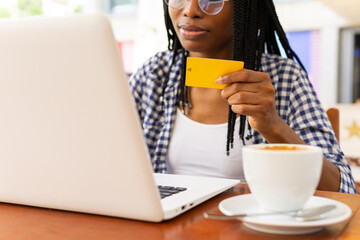 Black woman shopping online in a cafe