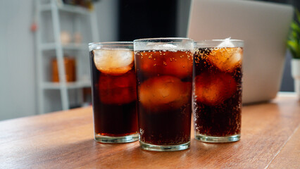 Double cool ice soft drink cola carbonated liquid fresh food with soda water, Cola drinking with ice in glass ready to refresh you, A cola soft drink is placed on the desk.