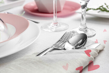 Table setting for romantic Valentine's day celebration. Plates, cutlery and hearts