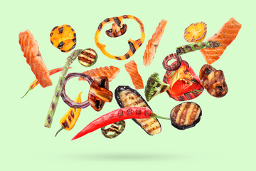 Delicious grilled salmon and vegetables falling on color background