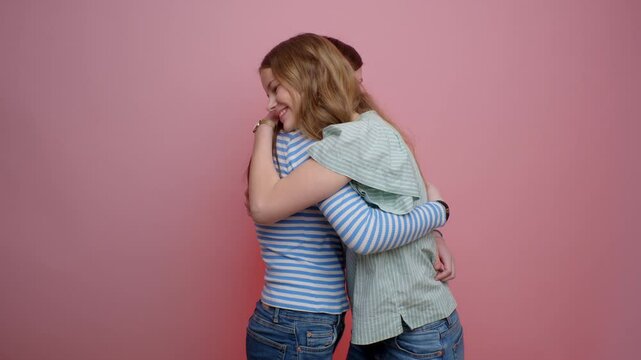 Girls Hugging Each Other On A Pink Background