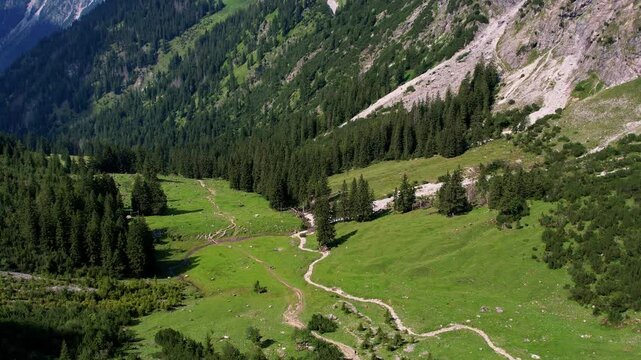 4K Aerial Drone video of the most beautiful mountain lake Schrecksee in Bavarian Alps with the cows feeding on lush green grass on a sunny day with blue skies and rocky hill tops surrounding