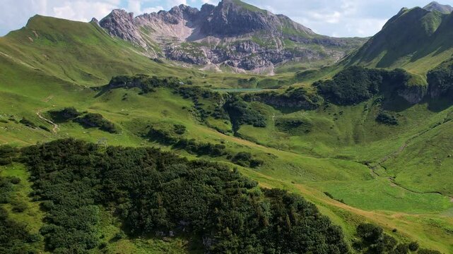 4K Aerial Drone video of the most beautiful mountain lake Schrecksee in Bavarian Alps with the cows feeding on lush green grass on a sunny day with blue skies and rocky hill tops surrounding